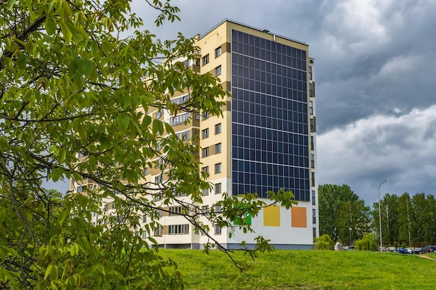 Pannelli solari sulla parete di un edificio a più piani su sfondo di alberi verdi Energia solare rinnovabile