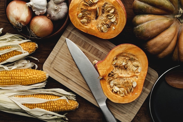 Pannocchia di mais e zucca sul bordo di legno marrone