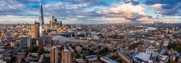 Panorama aereo del distretto finanziario della città di Londra con molti grattacieli iconici vicino al fiume Tamigi al tramonto.