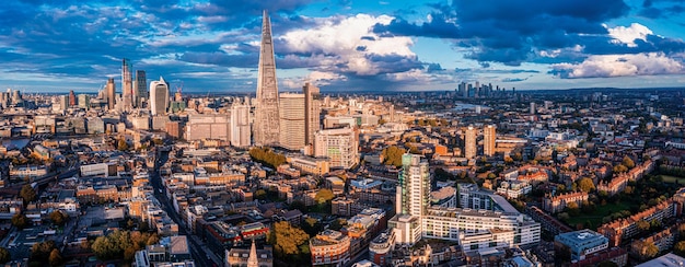 Panorama aereo del distretto finanziario della città di Londra con molti grattacieli iconici vicino al fiume Tamigi al tramonto.