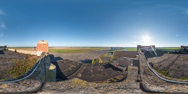 Panorama aereo sferico completo senza cuciture a 360 gradi con tetto in cemento abbandonato edificio incompiuto dell'aeroporto sulla pista in proiezione equidistante equirettangolare contenuto VR AR