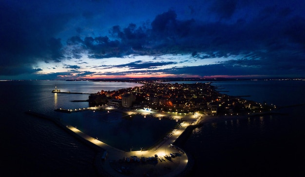 Panorama della città di Pomorie con hotel e luci bagnate dal Mar Nero sotto il cielo stellato in Bulgaria