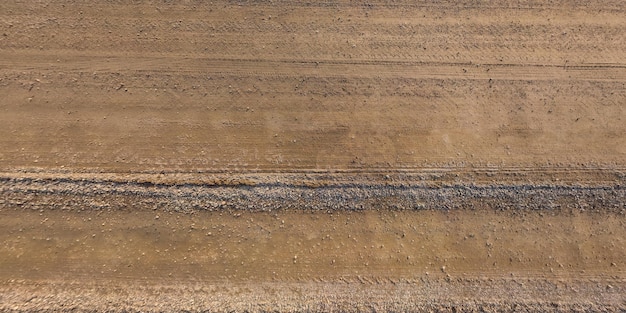 Panorama della superficie dall'alto della strada sterrata con tracce di pneumatici per auto