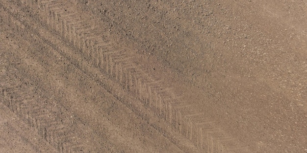 Panorama della superficie dall'alto della strada sterrata con tracce di pneumatici per auto