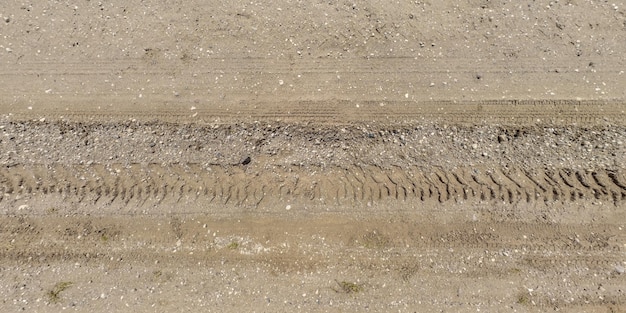 Panorama della superficie dall'alto della strada sterrata con tracce di pneumatici per auto