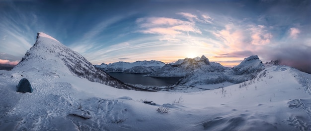 Panorama di escursionismo sulla catena montuosa innevata all'alba sul picco di Segla all'isola di Senja, Norvegia