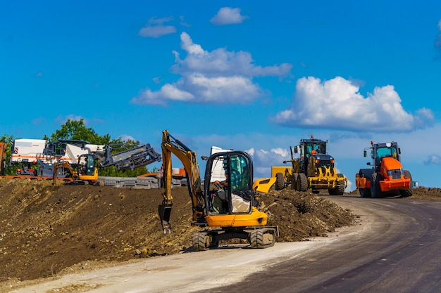 Panorama di macchine da lavoro su strada Costruzione di una nuova strada Diversi tipi di attrezzature stradali funzionanti