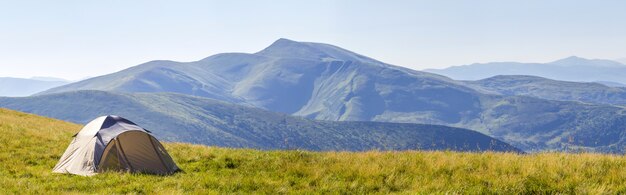 Panorama di montagna con tenda turistica.