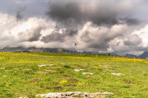 Panorama di montagna fiorito con cielo tempestoso in parapendio Monte Avena Belluno Italia