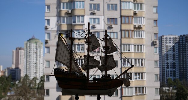 Panorama di paesaggio urbano sfocato con modello di nave a vela in legno su un primo piano