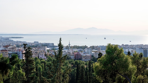 Panorama di Salonicco in Grecia da una collina, più edifici e il mare Egeo in lontananza, verdi alberi in primo piano