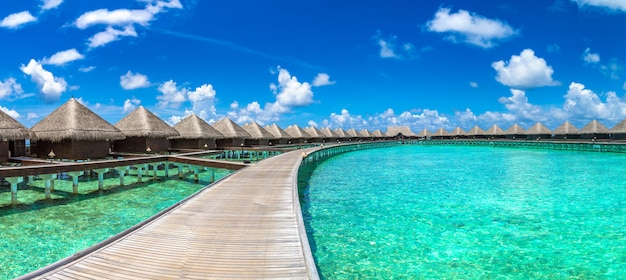 Panorama di Water Villas e ponte di legno in spiaggia tropicale