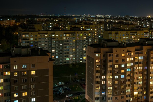 Panorama notturno di luce nelle finestre di una vita edilizia a più piani in una grande città