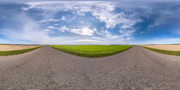 Panorama sferico completo senza interruzioni Vista angolare a 360 gradi su strada asfaltata senza traffico tra campi con cielo nuvoloso in proiezione equirettangolare Contenuto VR AR