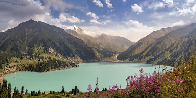 Panorama stupefacente di Big Almaty Lake il giorno di estate soleggiato con cielo nuvoloso, natura del Kazakistan.