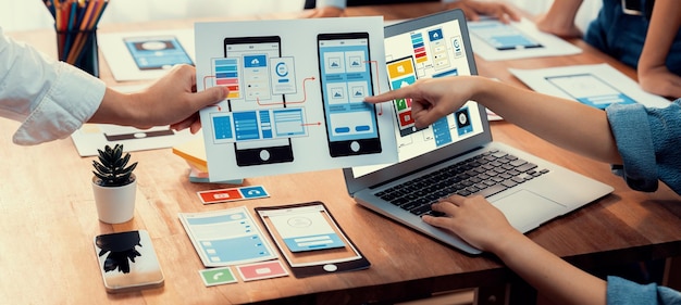 Panoramica del team di sviluppatori front-end durante il brainstorming dei progetti di UI e UX per l'app mobile sullo schermo del computer portatile Pianificazione del team di sviluppo dell'interfaccia utente per un design dell'interfaccia utente intuitivo Esaminare