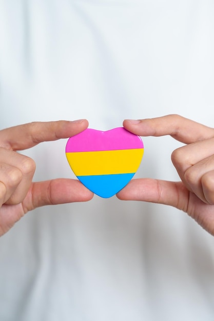 Pansexual Pride Day e LGBT Pride Month concetto mano che tiene a forma di cuore rosa giallo e blu per lesbiche gay bisessuali transgender queer e comunità pansessuale