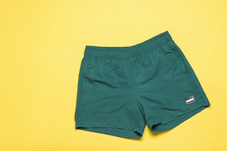 Foto pantaloncini da spiaggia da uomo alla moda su sfondo giallo. abbigliamento estivo popolare.