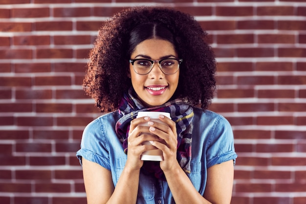 Pantaloni a vita bassa attraenti sorridenti con la tazza da portare via