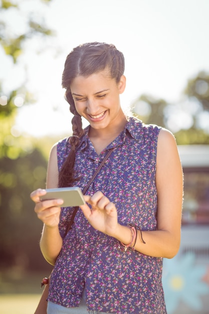 Pantaloni a vita bassa che controllano il suo telefono