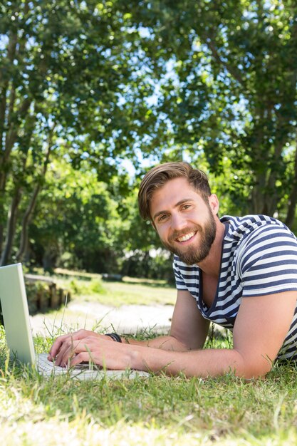 Pantaloni a vita bassa che utilizza computer portatile nel parco