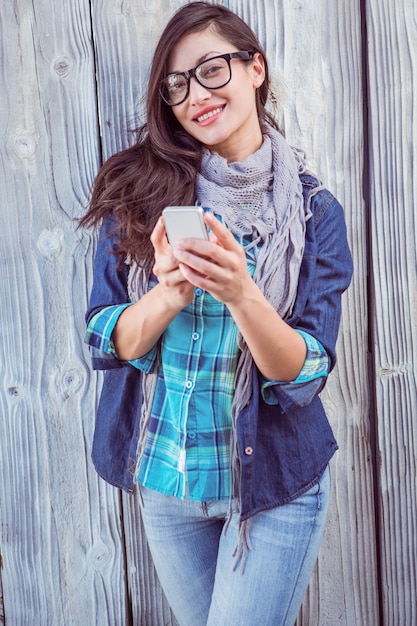 Pantaloni a vita bassa felici che tengono un telefono cellulare