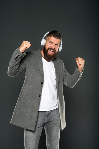 Pantaloni a vita bassa maturi felici con la barba. brutale hipster caucasico con i baffi. Mp3. tecnologia della vita moderna. Uomo in cuffia. Educazione audiolibro. L'uomo barbuto ascolta la musica. felice di essere qui.