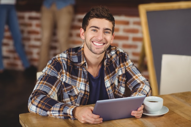 Pantaloni a vita bassa sorridenti facendo uso del computer della compressa