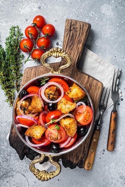 Panzanella tradizionale insalata italiana con pomodori cipolla e pane Crostini Sfondo grigio Vista dall'alto