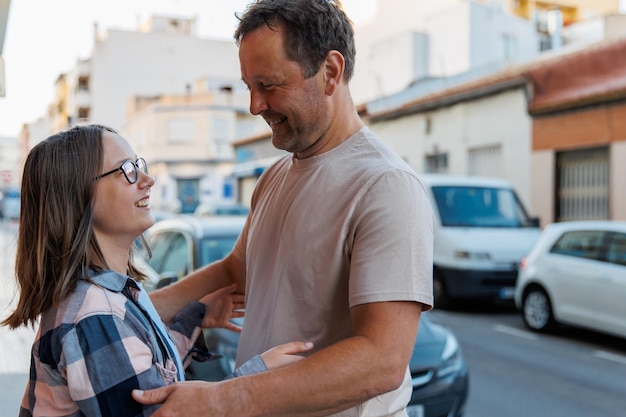 Papà abbraccia sua figlia in una strada cittadina