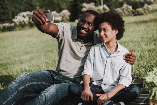 Papà abbraccia suo figlio e fa il selfie al picnic