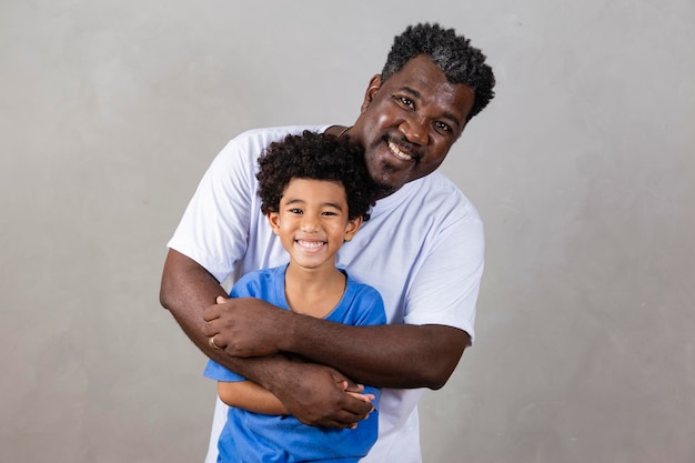 Papà afro e figlio nero su sfondo grigio papà afro sorridente e felice il giorno del papà festa del papà ad agosto