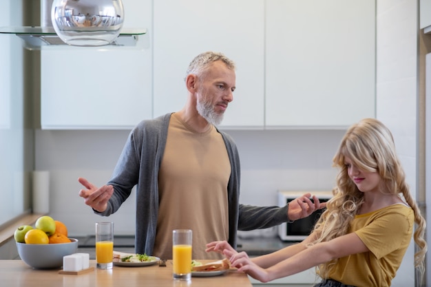 Papà che cerca di far fare colazione a sua figlia