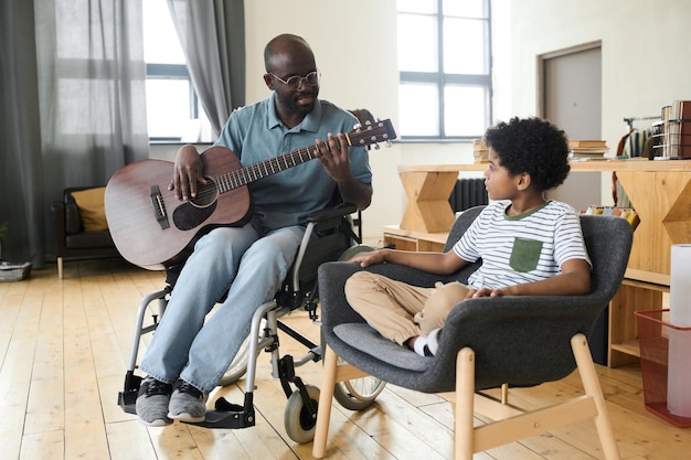 Papà che suona la chitarra per suo figlio