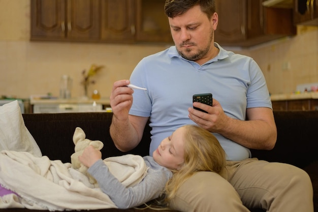 papà chiama la mamma dottore via video per consigliare la telemedicina del termometro per il trattamento del bambino