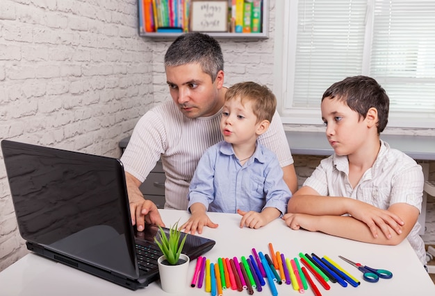 Papà e bambini che fanno video chat su tablet a casa homeschooling