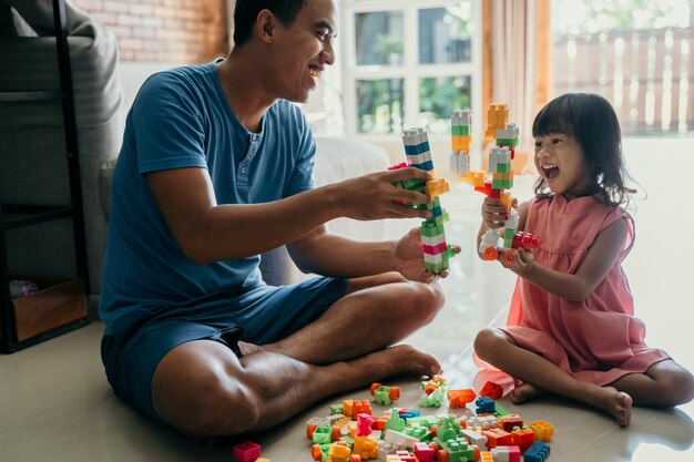 Papà e bambino che giocano con mattoni di plastica