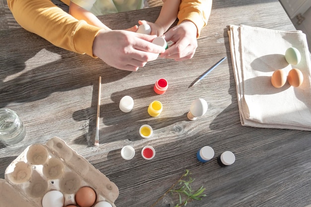 Papà e bambino dipingono le uova per Pasqua