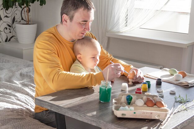 Papà e bambino dipingono le uova per Pasqua
