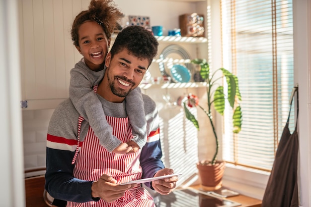 Papà e figlia che trovano insieme le ricette su un tablet