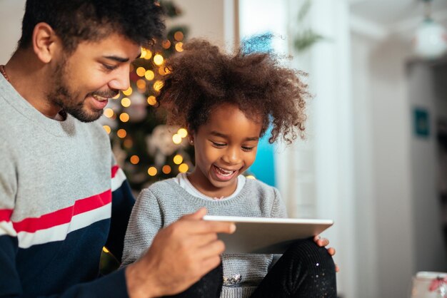 Papà e figlia usano il tablet e si divertono insieme