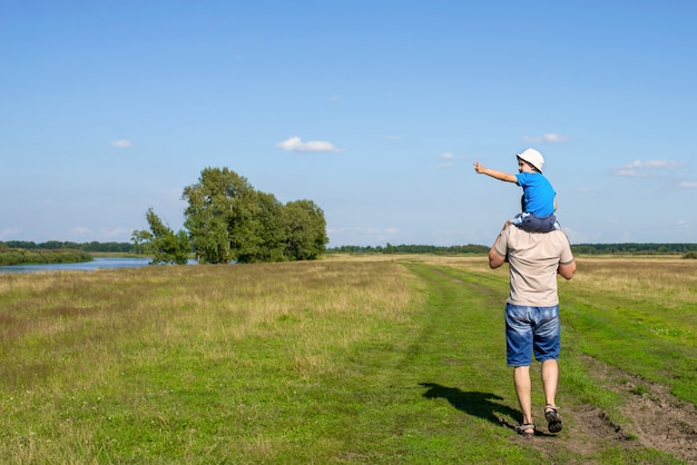 Papà e figlio camminano in estate fuori città