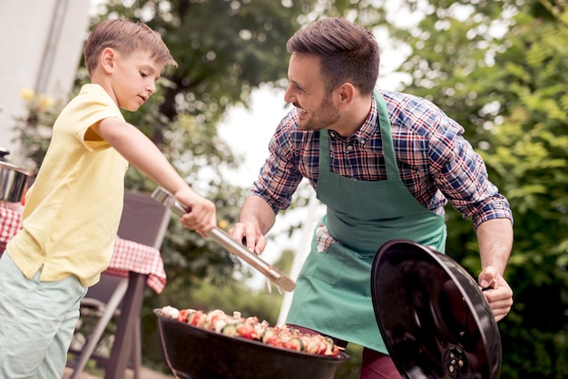 Papà e figlio che fanno una festa barbecue