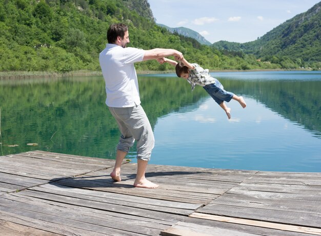 Papà e figlio che giocano sul lago di montagna