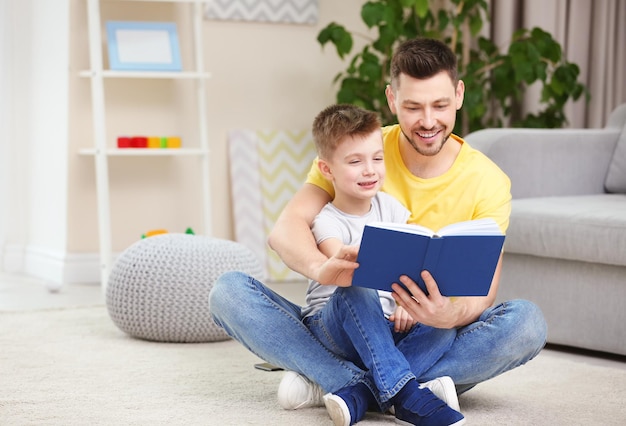 Papà e figlio che leggono un libro interessante a casa