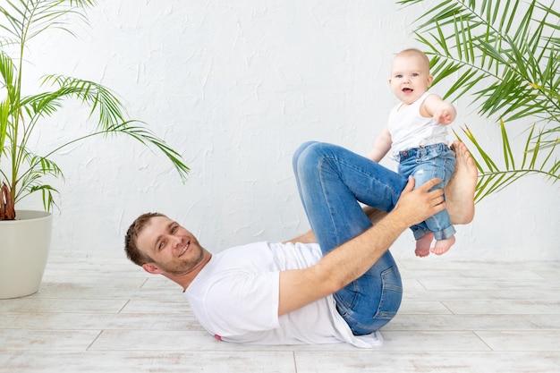 Papà e figlio del bambino fanno sport o si divertono giocando su uno sfondo bianco felice paternità e festa del papà di famiglia