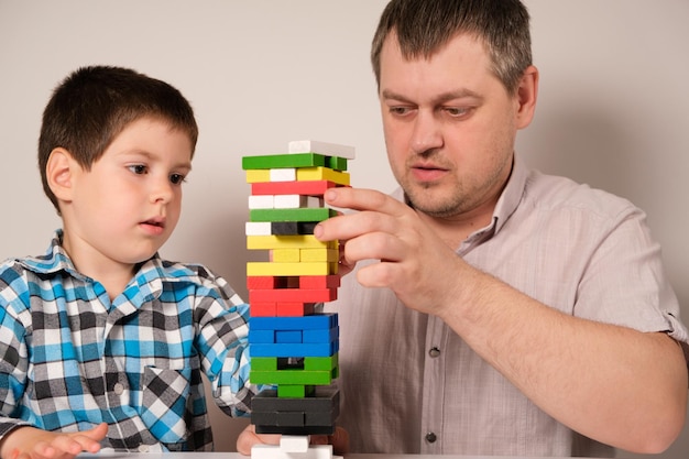 Papà e figlio giocano a un gioco da tavolo di jenga