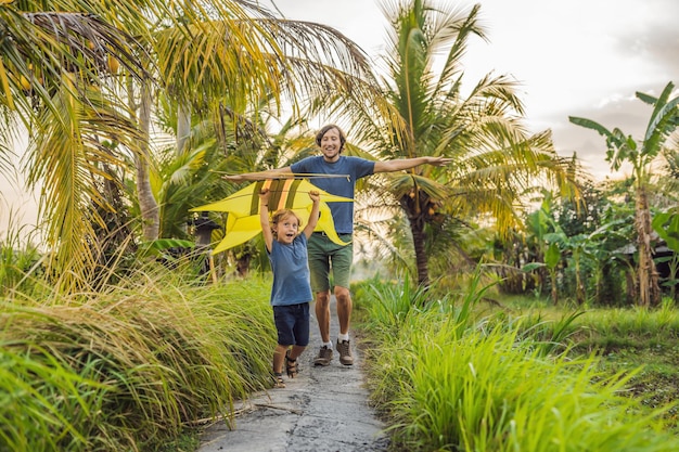 Papà e figlio lanciano un aquilone in una risaia a Ubud, nell'isola di Bali, in Indonesia