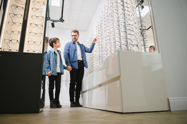 Papà e figlio scelgono nuovi occhiali eleganti in un negozio di ottica Concetto di cura della vista