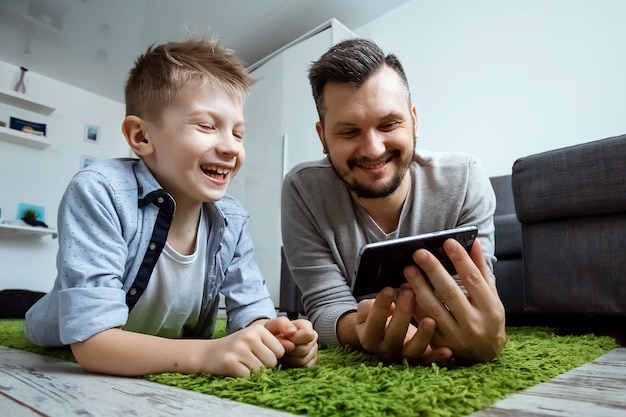 Papà e figlio sdraiati insieme sul pavimento